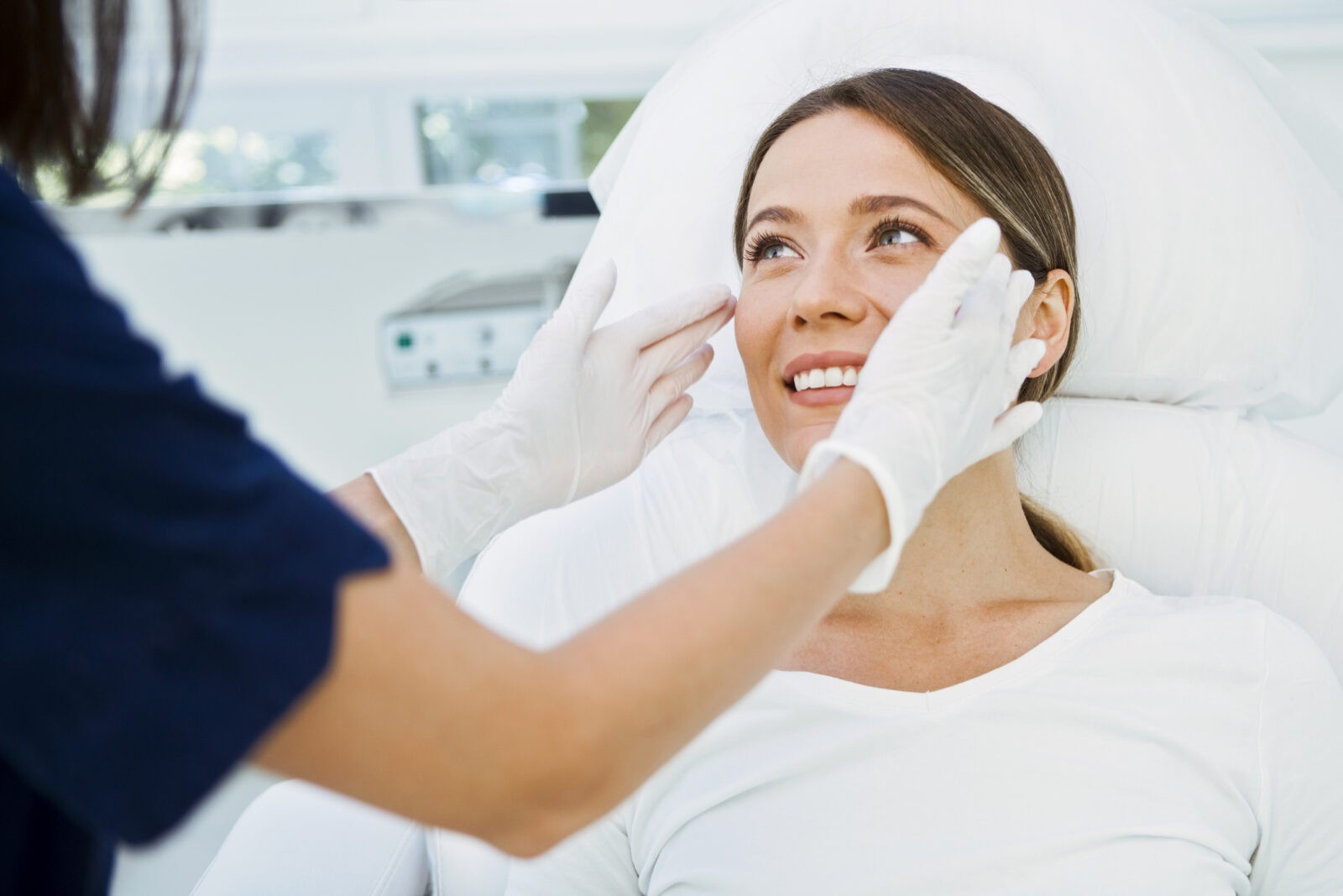 Cosmetologist preparing to doing cosmetic facial treatments for the young woman