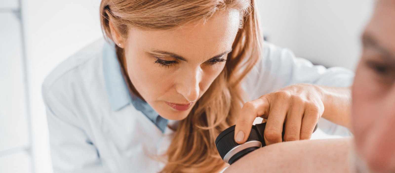 Doctor dermatologist examines skin of patient.